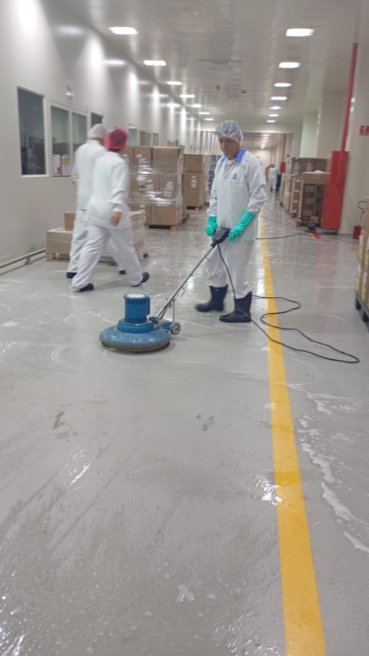 Equipe J.S.A realizando limpeza profissional de piso em ambiente industrial