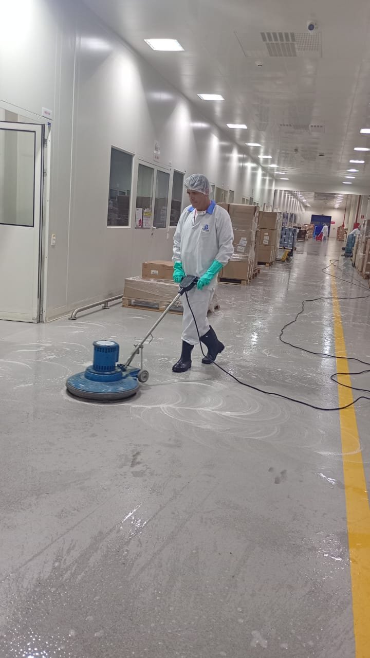 Profissional da J.S.A operando enceradeira em área industrial